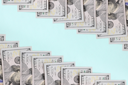 Row of a US dollar bills of a new design lies on a light blue background.の写真素材