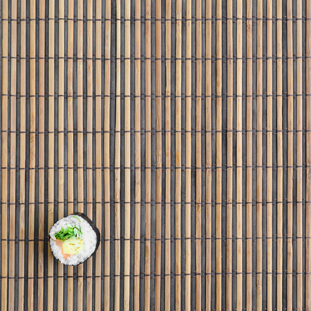 Sushi roll lie on a bamboo straw serwing mat. Traditional Asian food. Top view. Flat lay minimalism shot with copy space.の写真素材