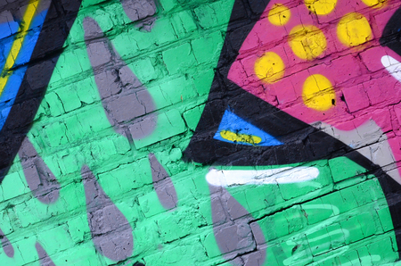 Fragment of graffiti drawings. The old wall decorated with paint stains in the style of street art culture. Colored background texture.の写真素材