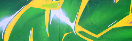 Fragment of graffiti drawings. The old wall decorated with paint stains in the style of street art culture. Colored background texture.の写真素材