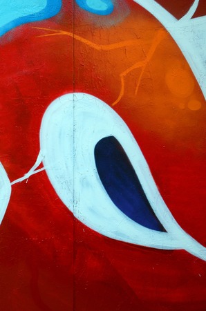 Fragment of graffiti drawings. The old wall decorated with paint stains in the style of street art culture. Colored background texture.の写真素材