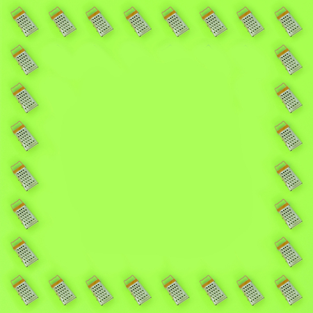 Small stainless steel graters lies on a pastel colored paper. Kitchen accessories. Tools for cooking. Flat lay top view.の写真素材