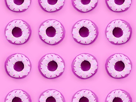 Many small plastic donuts lies on a pastel colorful background. Flat lay minimal pattern. Top view.