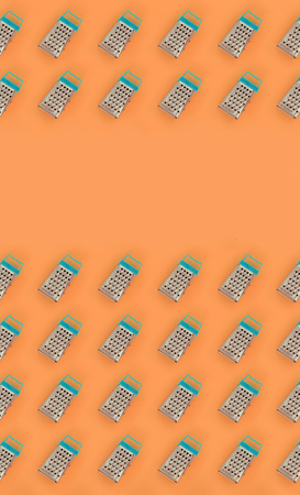 Small stainless steel graters lies on a pastel colored paper. Kitchen accessories. Tools for...