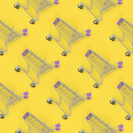 Shopping addiction, shopping lover or shopaholic concept. Many small empty shopping carts perform a pattern on a pastel colored paper background. Flat lay composition, top view.の写真素材