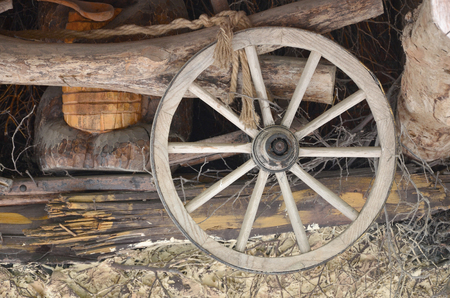 The old wooden wheel from the carriage hangs on the wall of the Ukrainian barnの写真素材