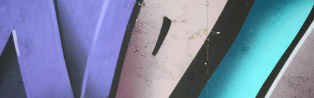 Fragment of graffiti drawings. The old wall decorated with paint stains in the style of street art culture. Colored background texture in cold tones.の写真素材