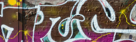 Fragment of graffiti drawings. The old wall decorated with paint stains in the style of street art...