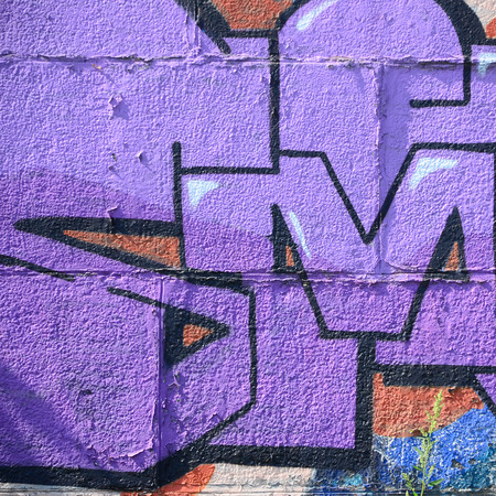 Fragment of graffiti drawings. The old wall decorated with paint stains in the style of street art culture. Colored background texture in purple tones.の写真素材