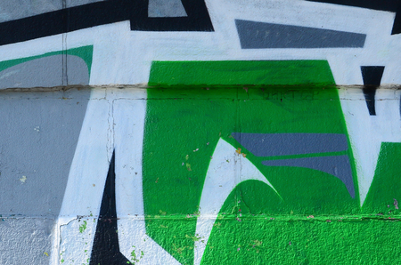 Fragment of graffiti drawings. The old wall decorated with paint stains in the style of street art culture. Colored background texture in green tones.の写真素材