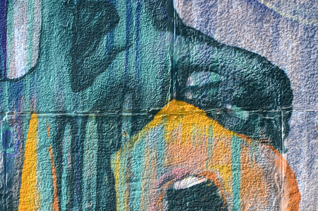 Fragment of graffiti drawings. The old wall decorated with paint stains in the style of street art culture. Colored background texture in warm tones.の写真素材