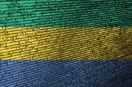 Gabon flag  is depicted on the screen with the program code. The concept of modern technology and...