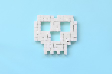 Sugar skull on a pastel blue background. Diabetic concept. Refusing sugar. Flat lay minimal top viewの写真素材