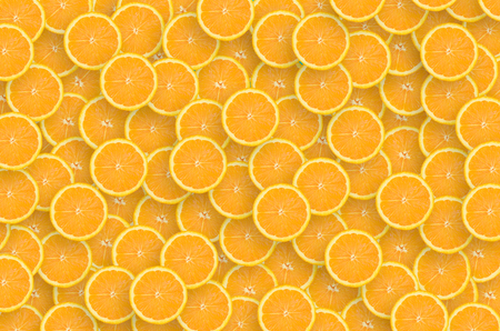 Top view of many orange fruit slices as a background image. A saturated citrus pattern. Flat lay