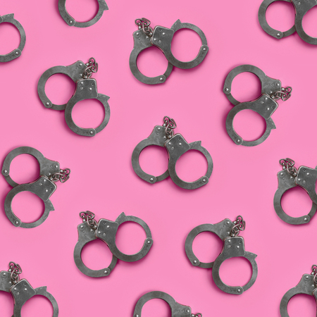 Bdsm sex games concept. Many steel handcuffs lies on pastel pink background. Bondage and Discipline, Domination and Submission, Sadism and Masochismの写真素材
