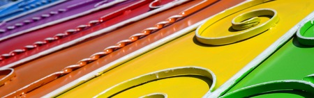Metal texture of a piece of colored wall with a forged pattern. Rainbow colors