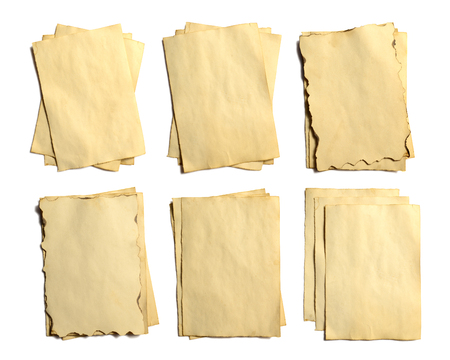 Set of old blank pieces of antique vintage crumbling paper manuscript or parchment vertically oriented isolated on whiteの写真素材