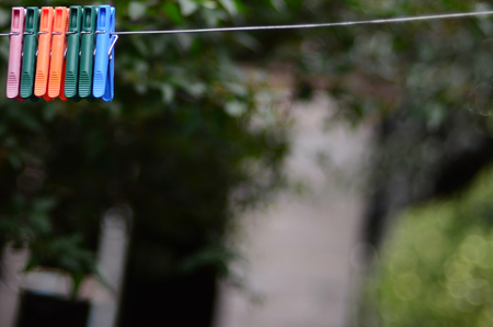 Clothespins on a rope hanging outside house, apple tree and blurred backgroundの写真素材