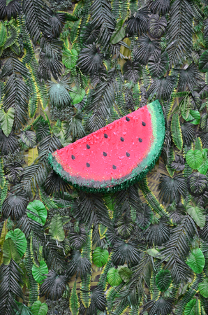 Tropical pattern with jungle leaves and watermelon fruit floral background. Plastic watermelon slice with palm leafの写真素材