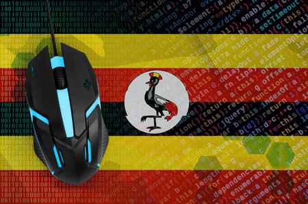 Uganda flag  and modern backlit computer mouse. The concept of digital threat, illegal actions on the Internetの写真素材