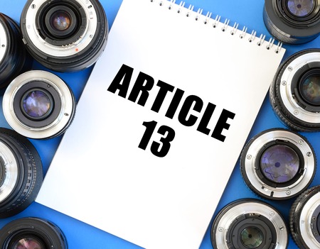 Two photographic lenses and notebook with article 13 inscription. European copyright directive...