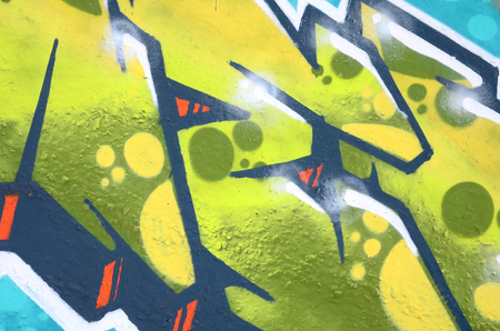 Fragment of colored street art graffiti paintings with contours and shading close up. Background texture of youth contemporary art culture. Green and yellow coloursのeditorial素材