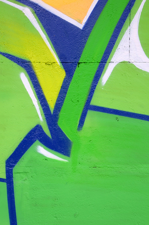 Fragment of colored street art graffiti paintings with contours and shading close up. Background texture of youth contemporary art culture. Green and yellow coloursのeditorial素材