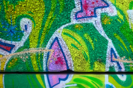 Fragment of colored street art graffiti paintings with contours and shading close up. Background texture of youth contemporary art culture. Green and yellow coloursのeditorial素材