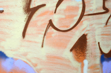 Fragment of colored street art graffiti paintings with contours and shading close up. Background texture of youth contemporary art culture. Beige brown colorsのeditorial素材