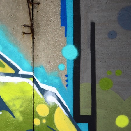 Fragment of colored street art graffiti paintings with contours and shading close up. Background texture of youth contemporary art culture. Green and yellow coloursのeditorial素材