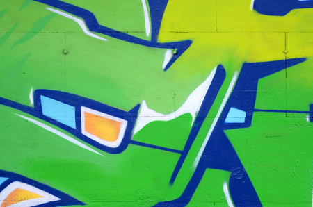 Fragment of colored street art graffiti paintings with contours and shading close up. Background texture of youth contemporary art culture. Green and yellow coloursのeditorial素材