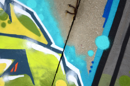 Fragment of colored street art graffiti paintings with contours and shading close up. Background texture of youth contemporary art culture. Green and yellow coloursのeditorial素材