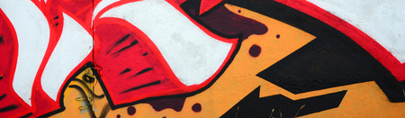 Fragment of colored street art graffiti paintings with contours and shading close up. Background texture of youth contemporary art culture. Orange, red and black coloursのeditorial素材