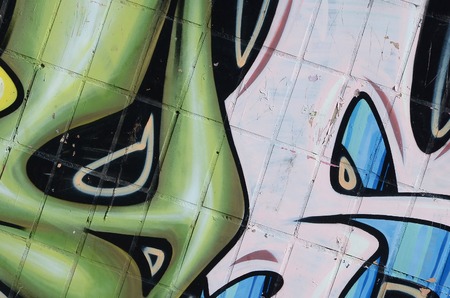 Fragment of colored street art graffiti paintings with contours and shading close up. Background texture of youth contemporary art culture. Green yellow colorsのeditorial素材