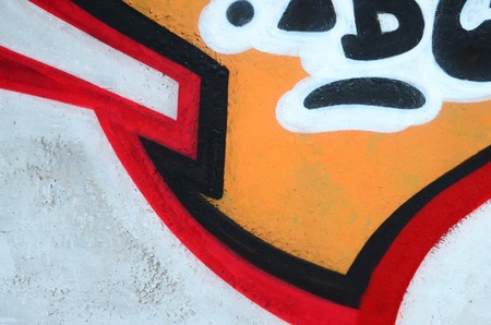 Fragment of colored street art graffiti paintings with contours and shading close up. Background texture of youth contemporary art culture. Orange, red and black coloursのeditorial素材