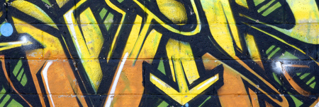 Fragment of colored street art graffiti paintings with contours and shading close up. Background texture of youth contemporary art culture. Yellow orange and brown colorsのeditorial素材
