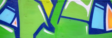 Fragment of colored street art graffiti paintings with contours and shading close up. Background texture of youth contemporary art culture. Green and yellow coloursの写真素材