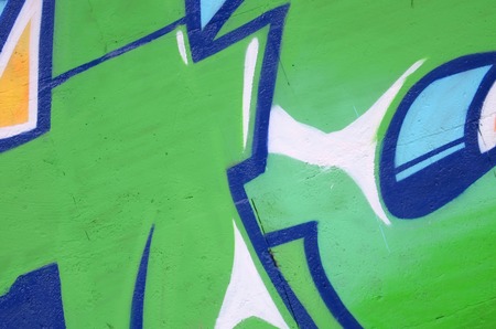 Fragment of colored street art graffiti paintings with contours and shading close up. Background texture of youth contemporary art culture. Green and yellow coloursの写真素材