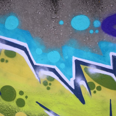 Fragment of colored street art graffiti paintings with contours and shading close up. Background texture of youth contemporary art culture. Green and yellow coloursの写真素材