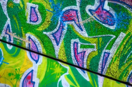 Fragment of colored street art graffiti paintings with contours and shading close up. Background texture of youth contemporary art culture. Green and yellow coloursの写真素材