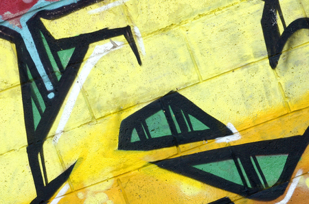 Fragment of colored street art graffiti paintings with contours and shading close up. Background texture of youth contemporary art culture. Yellow orange and brown colorsの写真素材