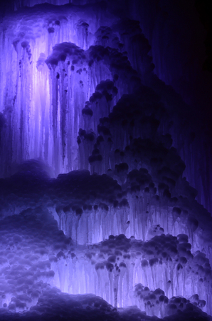 Huge ice icicles. Fragment of large blocks of ice frozen waterfall of water. Blue ice cavern background. Frozen stream waterfallの写真素材