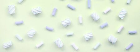 Colorful marshmallow laid out on lime paper background. pastel creative texture. minimal.