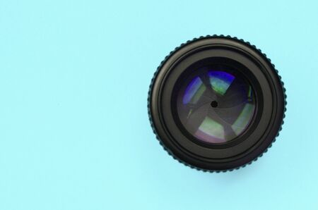 Camera lens with a closed aperture lie on texture background of fashion pastel blue color paper in minimal conceptの写真素材