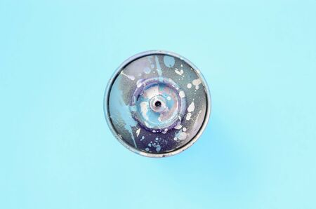 Used spray can with blue paint drips lie on texture background of fashion pastel blue color paper in minimal concept.の写真素材