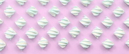Colorful marshmallow laid out on pink paper background. pastel creative textured pattern. minimal.の写真素材