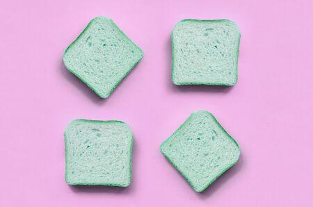 A few pieces of green bread lies on texture background of fashion pastel pink color paper in minimal...