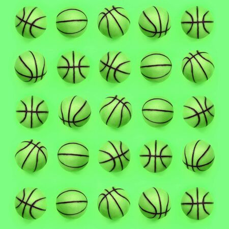 Many small green balls for basketball sport game lies on texture background of fashion pastel green color paper in minimal concept.の写真素材