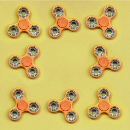 Many orange fidget spinners lies on texture background of fashion pastel orange color paper in minimal concept.の写真素材