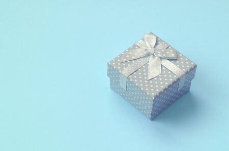 Small blue gift box lie on texture background of fashion pastel blue color paper in minimal concept.